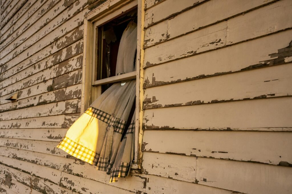 An exterior dryer vent hood on a house wall with the flap open.