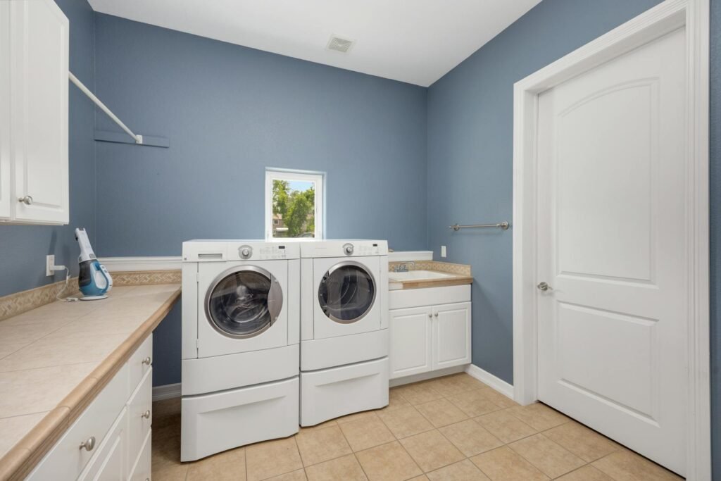 A clean utility space with a modern water heater, drain pan, and leak sensor.