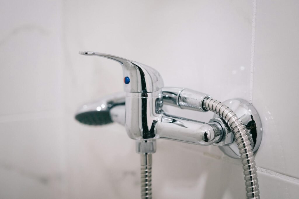 Person inspecting shower corners and tub edge with a flashlight