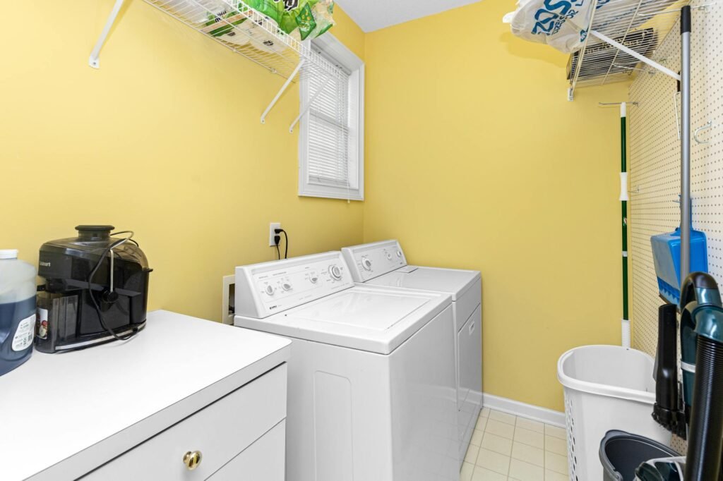 A dryer pulled away from the wall so the metal vent connection can be inspected.