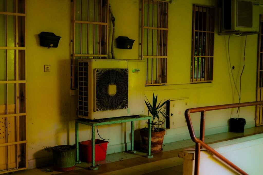 A person comparing airflow at a home vent while writing notes.