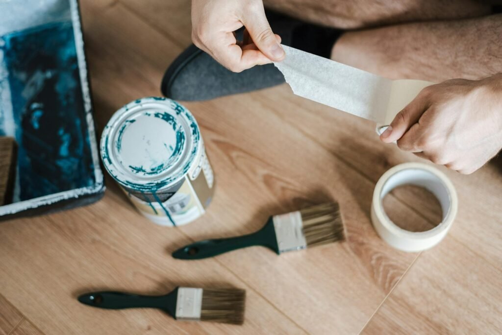 Silicone caulk, scraper, painter’s tape, and cleaning cloths laid out on a countertop