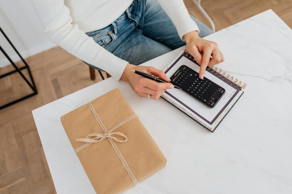 A seasonal home maintenance checklist on a kitchen table with a calendar, flashlight, pen, and household bills