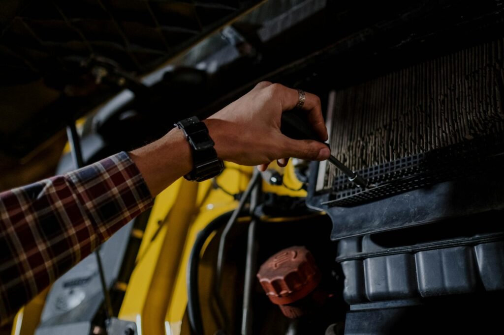 A close-up of a pleated HVAC filter being removed from a return grille in a home.