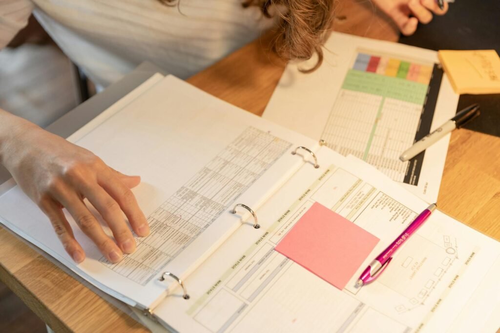 A home file binder with manuals, warranty papers, and receipts arranged on a desk.