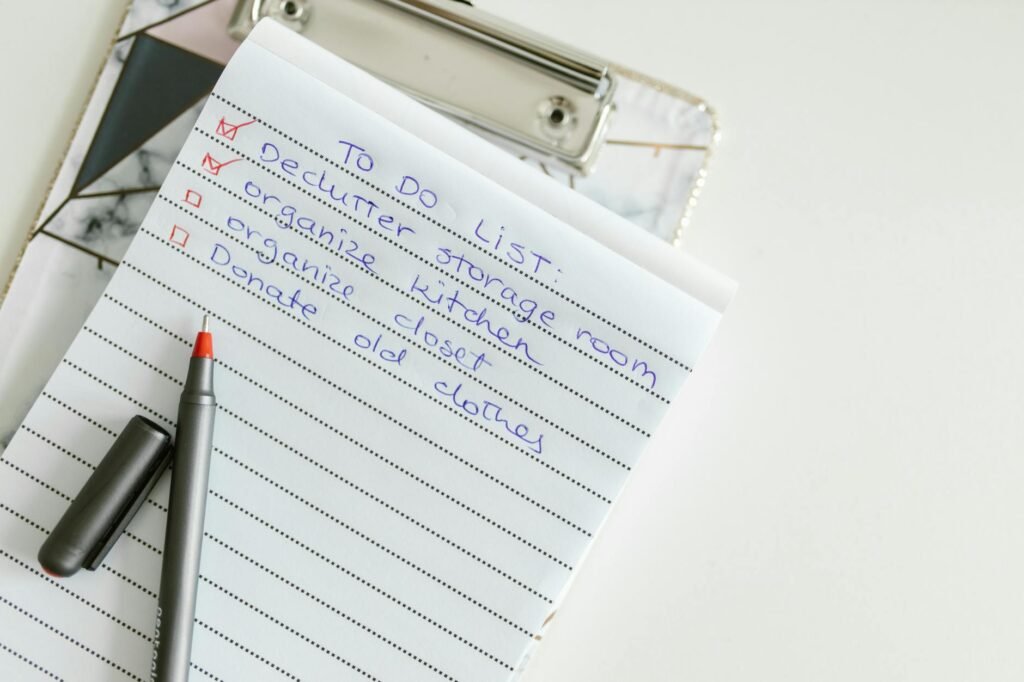 A paper home maintenance checklist and calendar reminder next to simple cleaning tools.