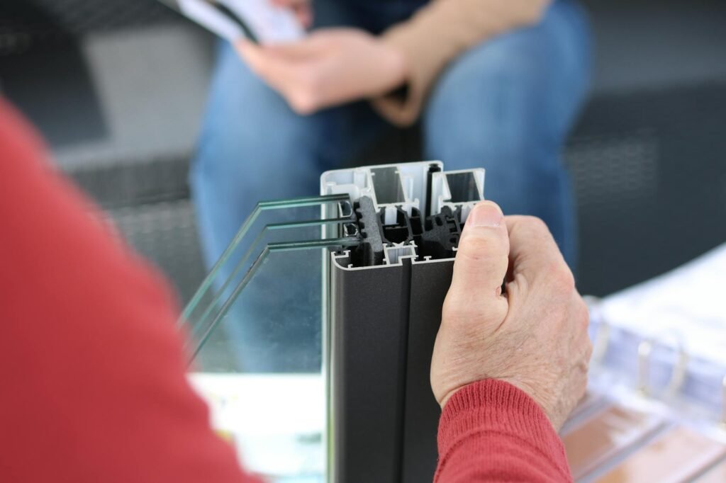 A hand held near a window frame to check for a draft.