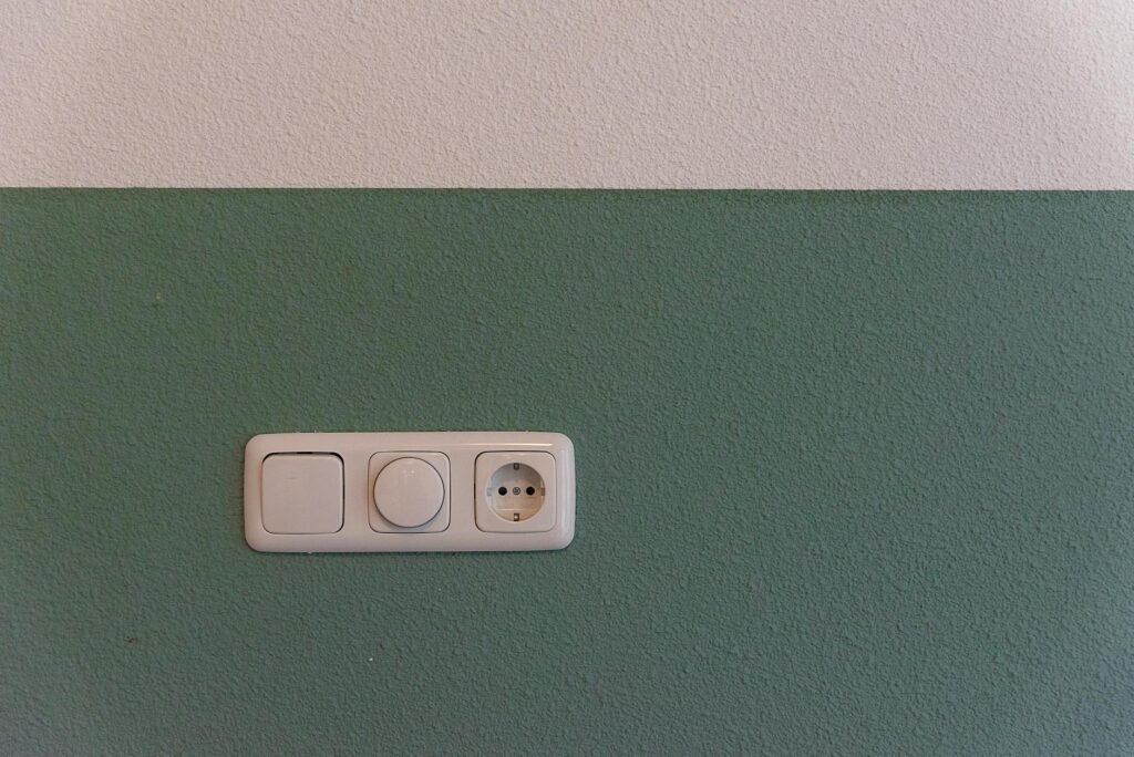 Close-up of a household wall outlet in a kitchen with one appliance plugged in