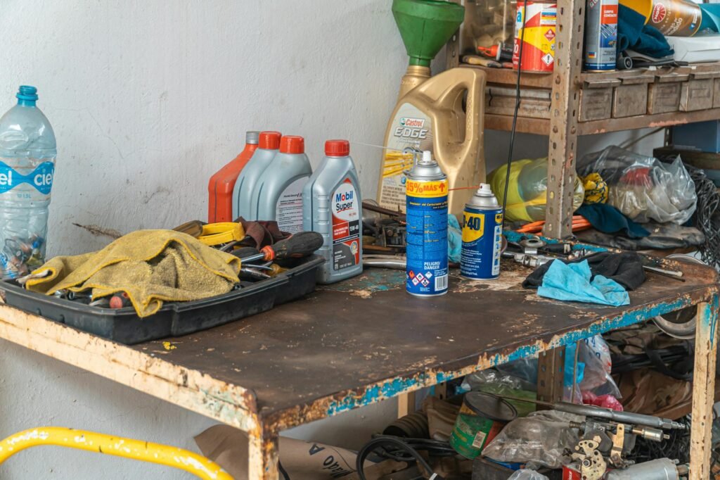 Homeowner applying garage door lubricant to metal hinges and rollers.