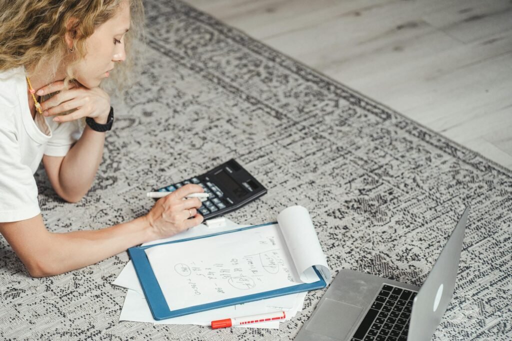 A desk setup with a calculator, repair paperwork, and a home maintenance checklist.