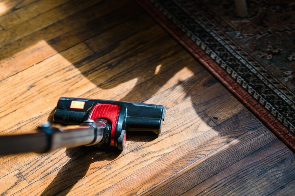 Owners manual, vacuum attachment, and soft brush next to a refrigerator